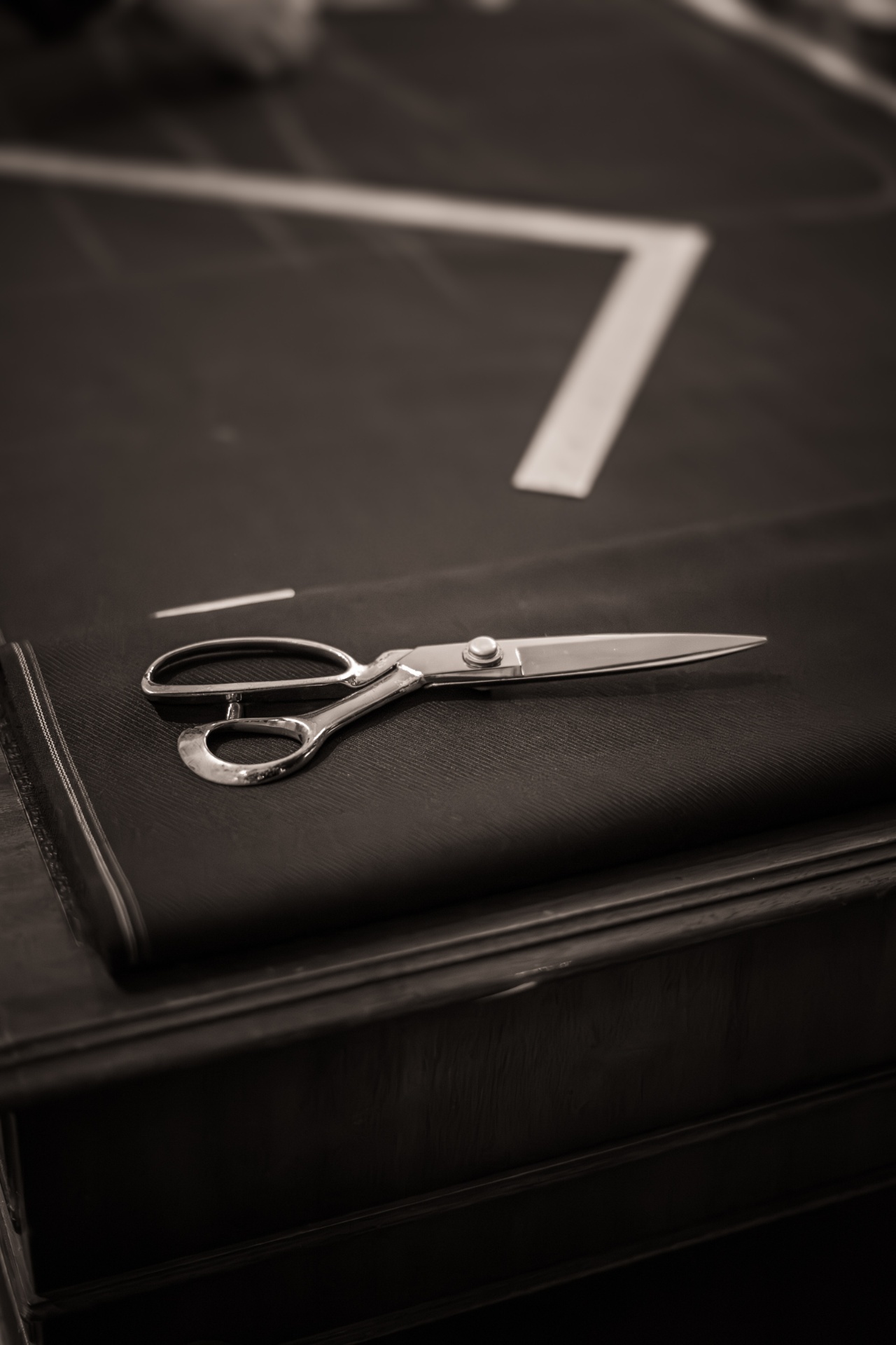 Tailor's shears resting on a bolt of dark cloth